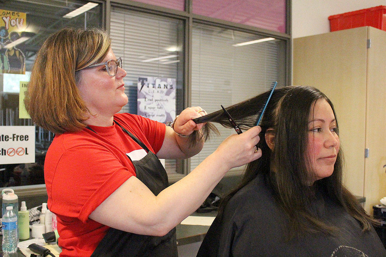 Andrya Rytter, owner of Level Seven Salon in Bothell, gives Vanessa Rivera a haircut at the sixth annual Care Day at Northshore Middle School. Madison Miller/staff photo