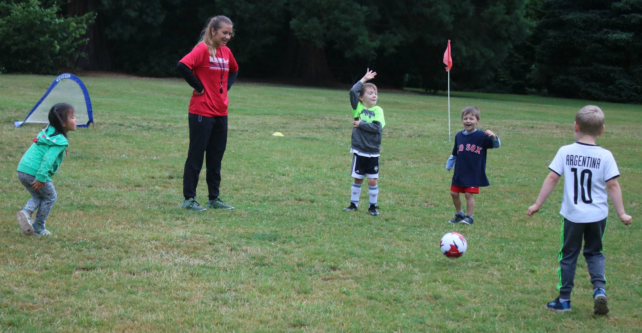Amber Powers, director and coach of the Kenmore Skyhawks Sports youth soccer camp, enjoys her time with the kids on July 17 at Rhododendron Park. Andy Nystrom/ staff photo