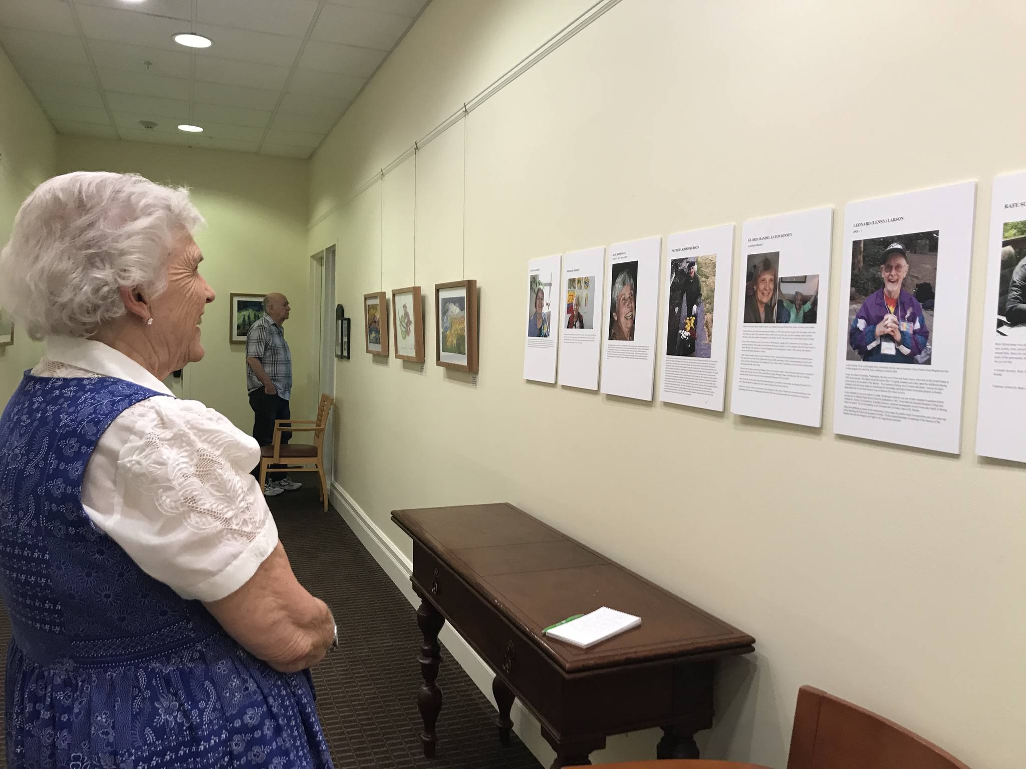 Dianne Miller reads about the artists featured in “The Art of Alzheimer’s” exhibit, currently at The Gardens at Town Square. Samantha Pak/staff photo
