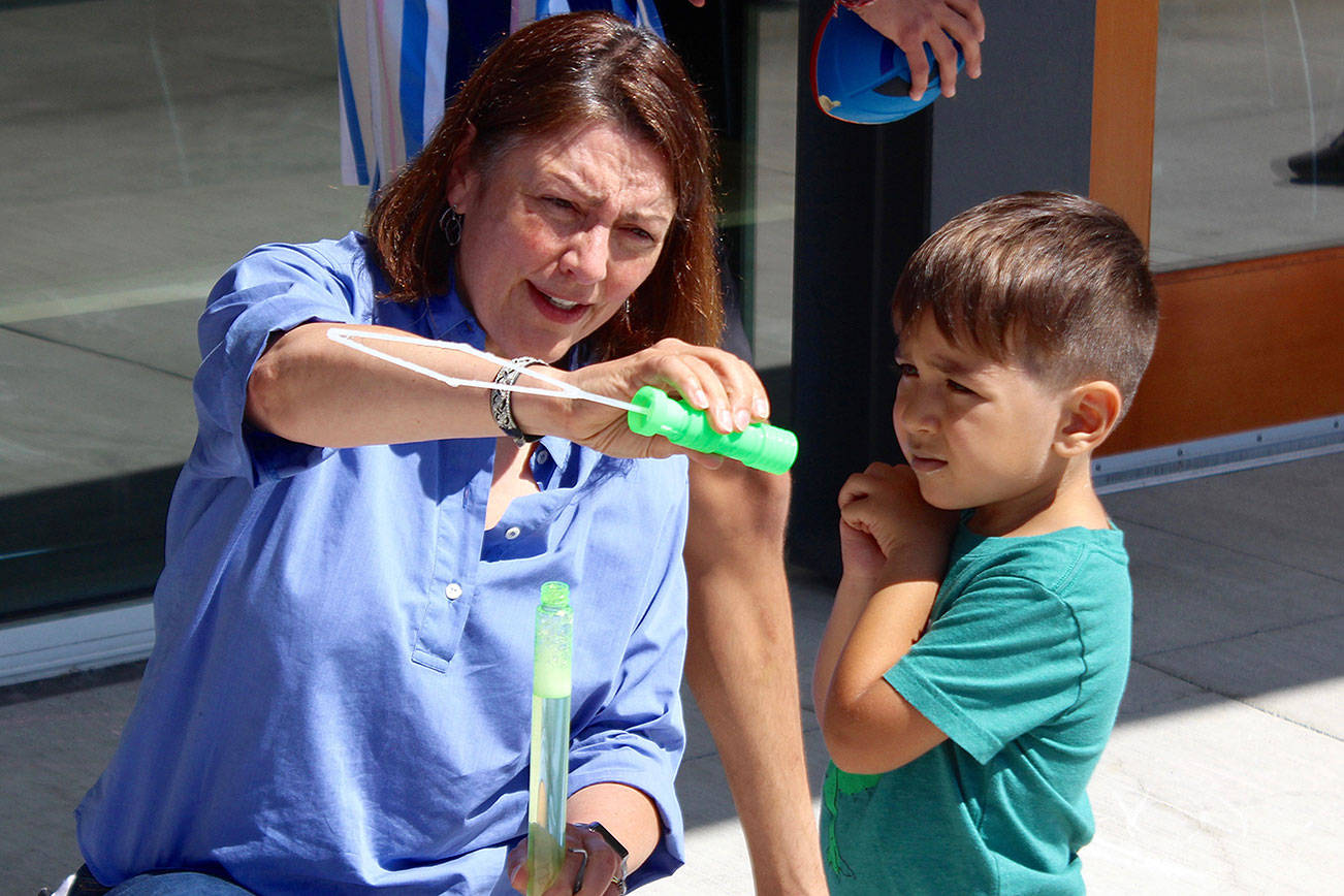 Rep. DelBene helps one of the children at the event blow bubbles. Blake Peterson/staff photo