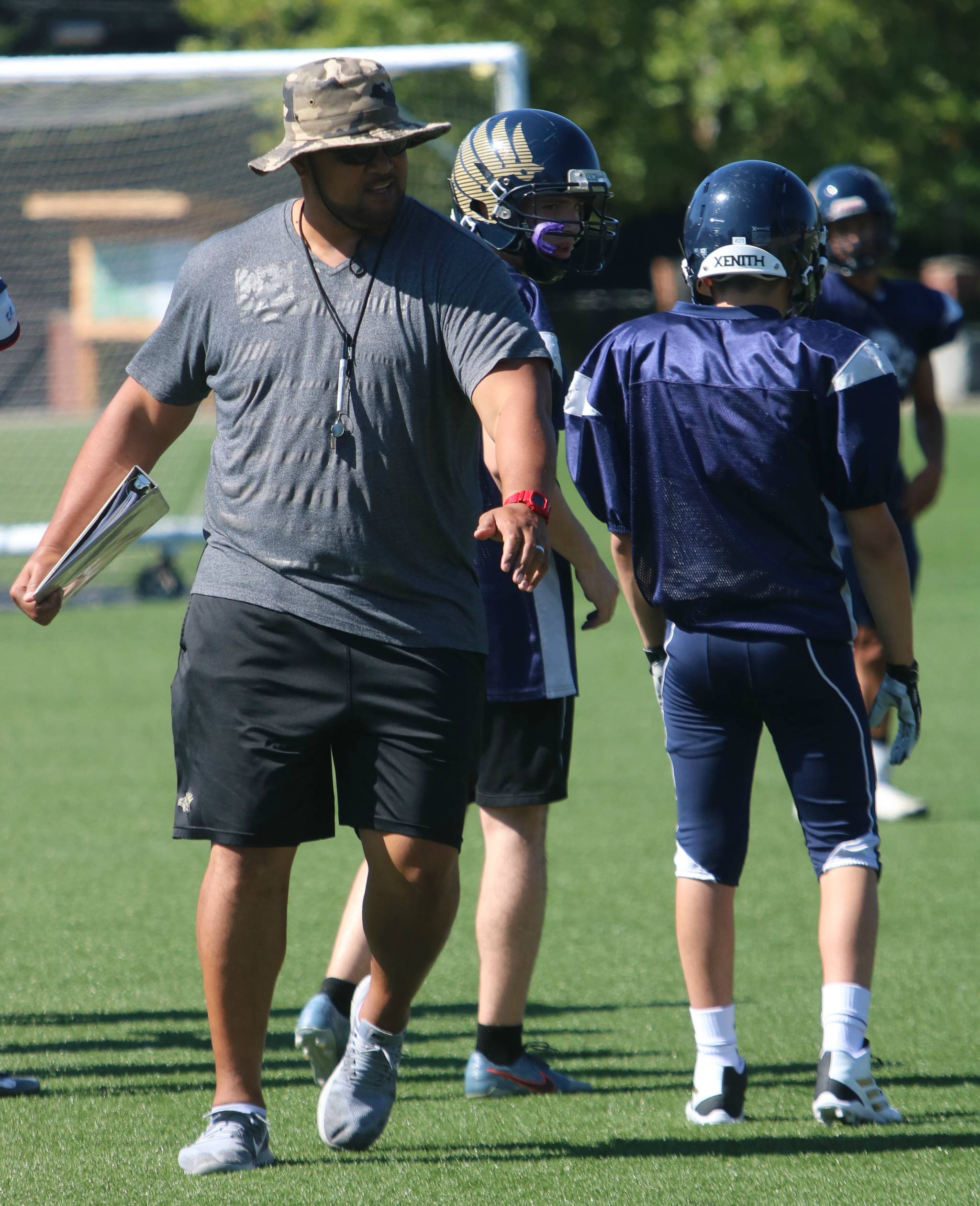 Eagle head coach Manase Hopoi shows players how to break through the line. Andy Nystrom/ staff photo