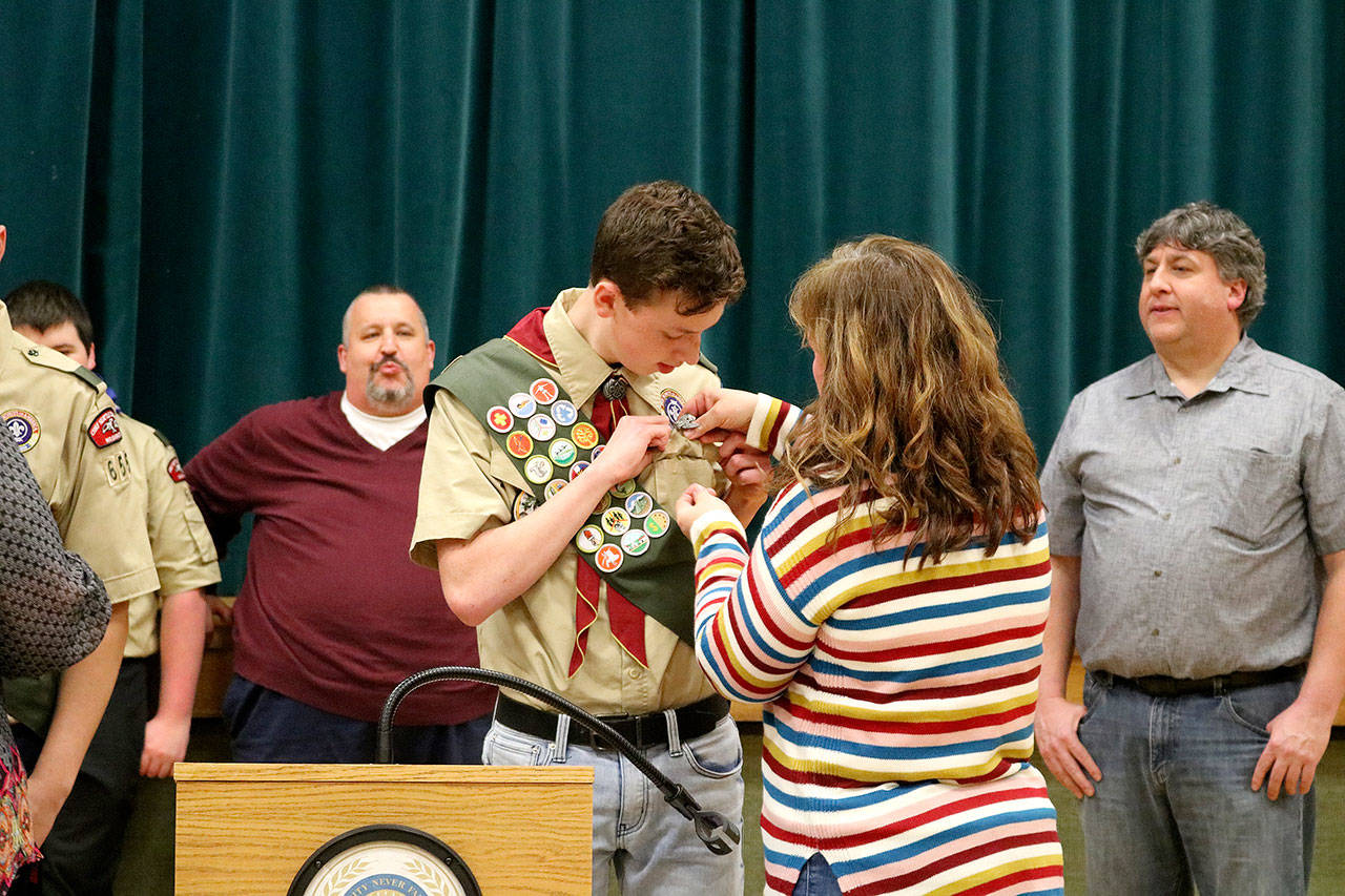 Stephanie Quiroz/staff photo                                 Debbie Hogge pins her son, Spencer Hogge, at his Eagle Scout ceremony for Troop 655 on Dec. 27.