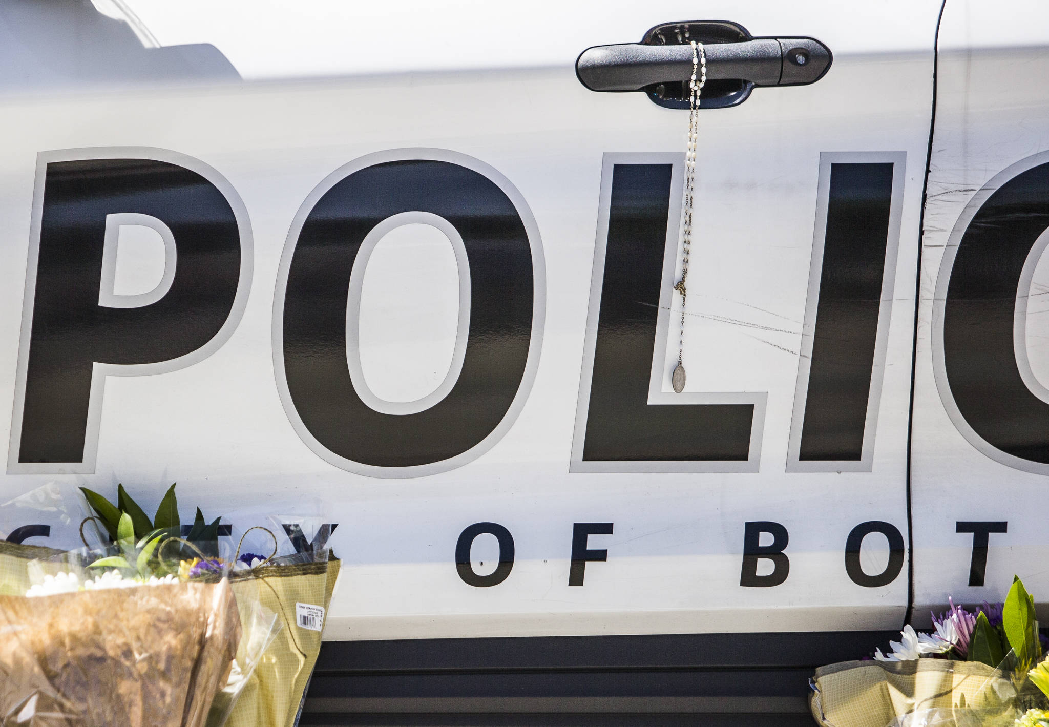 A rosary hangs from a Bothell Police Department vehicle door handle on Tuesday in Bothell. (Olivia Vanni / The Herald)