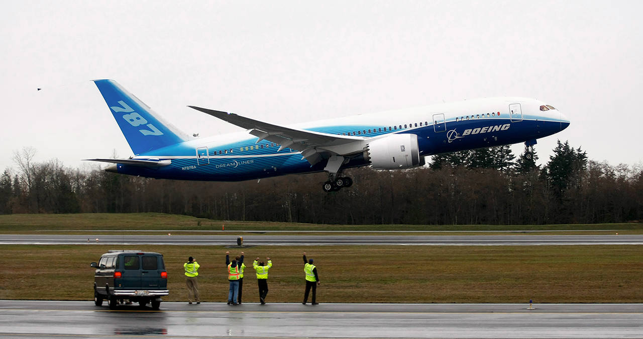 Workers cheer and wave as Boeing’s 787 Dreamliner takes off from Paine Field on Dec. 15, 2009. (Justin Best/ Herald file)