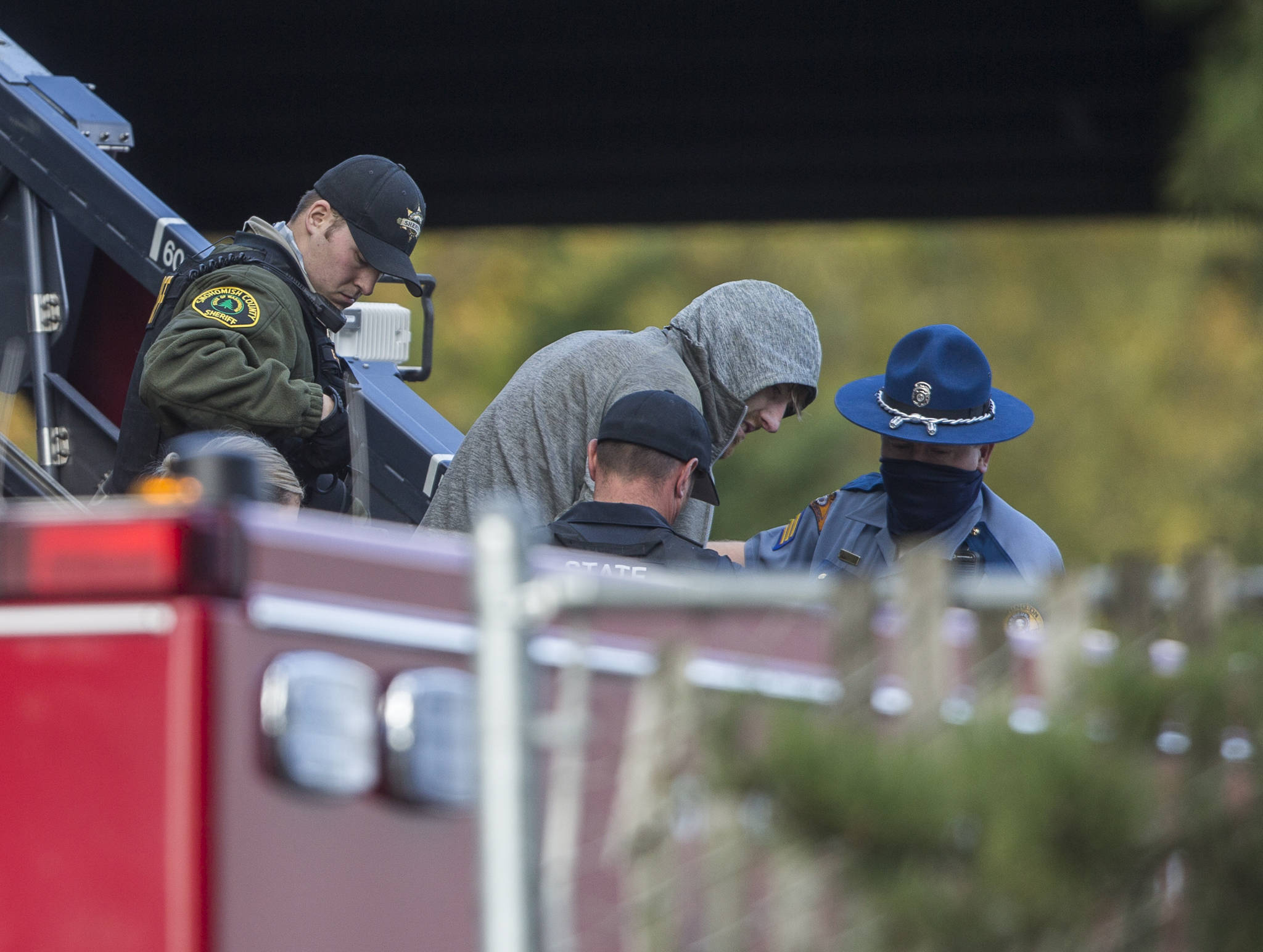 The carjacking suspect is handcuffed before being transferred to a stretcher on Wednesday near Mill Creek. (Olivia Vanni / The Herald)