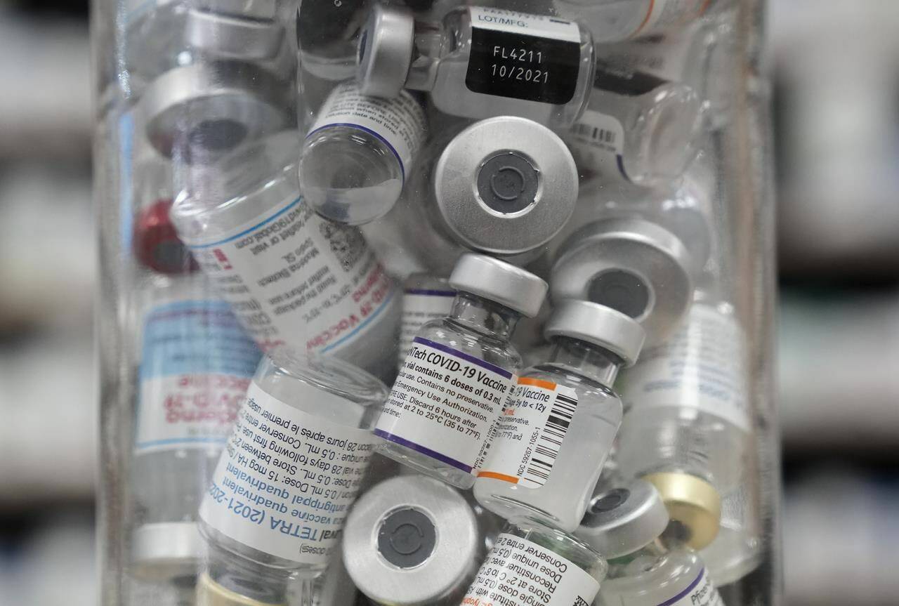A jar full of empty COVID-19 vaccine vials is shown at the Junction Chemist pharmacy during the COVID-19 pandemic in Toronto on Wednesday, April 6, 2022. As the U.K. has kicked off the global race to greenlight an updated version of the COVID-19 vaccine, anticipation is mounting for Canada to follow suit as fall threatens to usher in a new wave of infections. THE CANADIAN PRESS/Nathan Denette