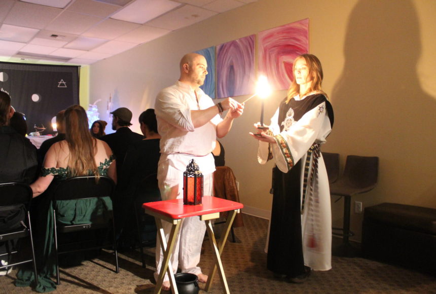 <p>High Priest Kalu and High Preistess Syleena “Call The Corners,” a small ritual where a candle is lit at each direction of the Earth as the elements of each direction is called upon. Here they call on the guardian of the watchtower of the South, represented by red which symbolizes fire. Photo by Bailey Jo Josie/Sound Publishing.</p>