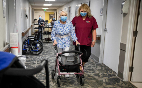 CNA Nina Prigodich, right, goes through restorative exercises with long term care patient Betty Long, 86, at View Ridge Care Center on Friday, Feb. 10, 2023 in Everett, Washington. (Olivia Vanni / The Herald)