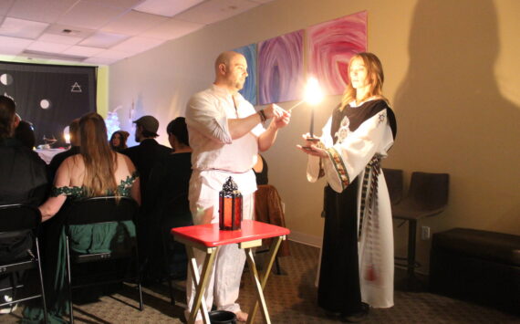 High Priest Kalu and High Preistess Syleena “Call The Corners,” a small ritual where a candle is lit at each direction of the Earth as the elements of each direction is called upon. Here they call on the guardian of the watchtower of the South, represented by red which symbolizes fire. Photo by Bailey Jo Josie/Sound Publishing.