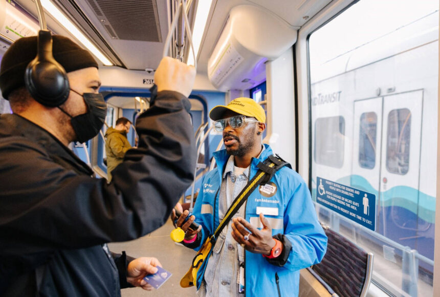 <p>A Sound Transit fare ambassador checks with a light rail rider. COURTESY PHOTO, Sound Transit</p>