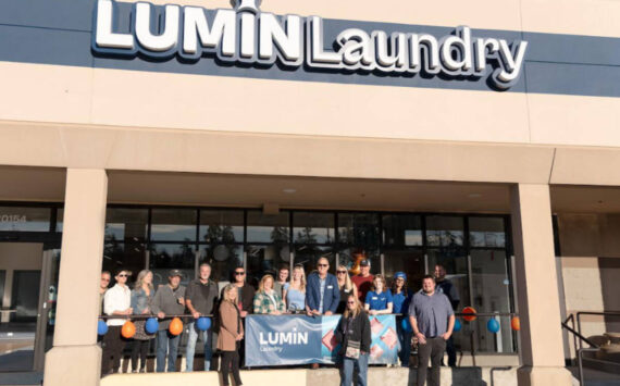 Lumin Laundry owners and staff gathered with the Edmonds Chamber of Commerce for the ribbon cutting at their grand opening. Photo courtesy Lumin Laundry.