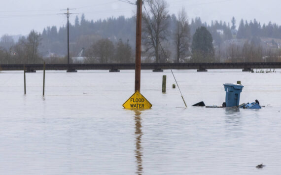 Floodwater from the Snohomish River partially covers a flood water sign on Thursday, Dec. 11, 2025 in Snohomish, Washington. (Sound Publishing photo)