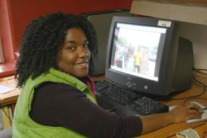 Bastyr University graduate and post-doctoral researcher Marie-Sabine Thomas in her university office. On her computer screen is a shot of her in Haiti with other aid workers.
