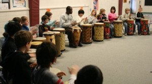 Ghanaian drummer Sowah Mensah teaches some techniques to Kenmore fourth graders.