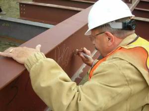 Kenmore Mayor David Baker signs the final steel beam that workers placed at the new City Hall location Oct. 1.  Construction on the new building