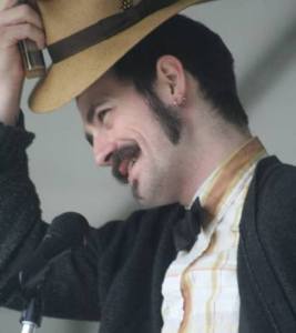Harmonica player Ryan Koenig of the Pokey LaFarge and the South City Three band thanks the crowd for its applause after unleashing a solo during Thursday's Kenmore Concert Series performance at St. Edward State Park.