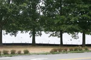A large white tarp covers up some dirt on Bothell Way Northeast.