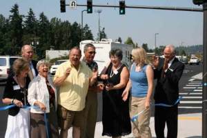 Local and state notables celebrate the cutting of a ceremonial ribbon marking completion of the first portion of a planned three-phase rebuilding of State Route 522 in Kenmore. Celebrants included