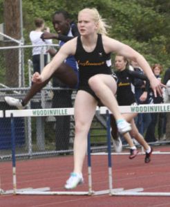 Inglemoor High’s Becca Berge outleaps Bothell High’s Charnele Odingo on her way to winning the 100-meter hurdles last Thursday at Woodinville High. PHOTOS BY ANDY NYSTROM
