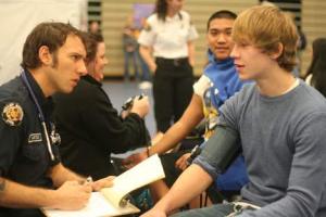 Firefighter Reed Astley checks Bothell High senior Ryan Carter’s blood pressure.