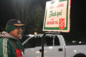 Alfredo Morales braves the cold and smiles at a shopper on Monday night while collecting holiday donations for The Salvation Army at the Kenmore Safeway on Northeast Bothell Way. Morales and other bell-ringers will be on hand through Dec. 24.