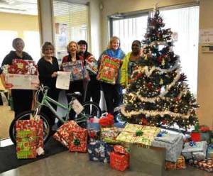 Republic Services employees gather around the Christmas tree just before loading gifts into the truck for delivery.