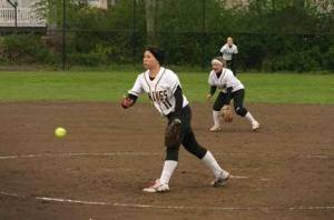 Inglemoor High starting pitcher Rosie Matsumoto throws in the first inning of Inglemoor's Friday afternoon fastpitch matchup against Redmond while shortsop Kaylee Hardin and center fielder Jenna Rutherford (back) are ready to defend. Matsumoto scattered seven hits over seven innings and gave up just a solo home run as the Vikings won