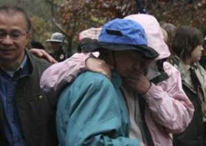 Members of First Lt. Nicholas Madrazo's family look down at the brick that was dedicated to the fallen soldier at a Veteran's Day memorial event this morning at the Park at Bothell Landing. A brick was also dedicated to Cpl. Jason Bogar