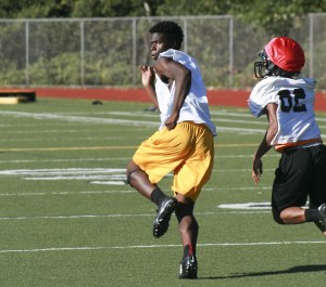 Inglemoor senior Chinedu Ugokwoli runs away from a defensive back during preseason training. Already a standout basketball player