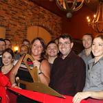 Owner Dusty DuBois (center, with the scissors) celebrates the grand opening of Revolve True Food and Wine Bar alongside the restaurant&rsquo;s staff. Contributed photo