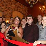 Owner Dusty DuBois (center, with the scissors) celebrates the grand opening of Revolve True Food and Wine Bar alongside the restaurant&rsquo;s staff. Contributed photo