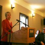 Bothell City Manager Jennifer Phillips delivers her first State of the City address during the Bothell Chamber of Commerce luncheon as Bothell Mayor Andy Rheaume looks on from the front row. CATHERINE KRUMMEY/Bothell Reporter