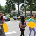 Frank Love Elementary School staff and students use the new pedestrian flags at the intersection of Fourth Avenue West and 224th Street Southwest. CATHERINE KRUMMEY, Bothell/Kenmore Reporter