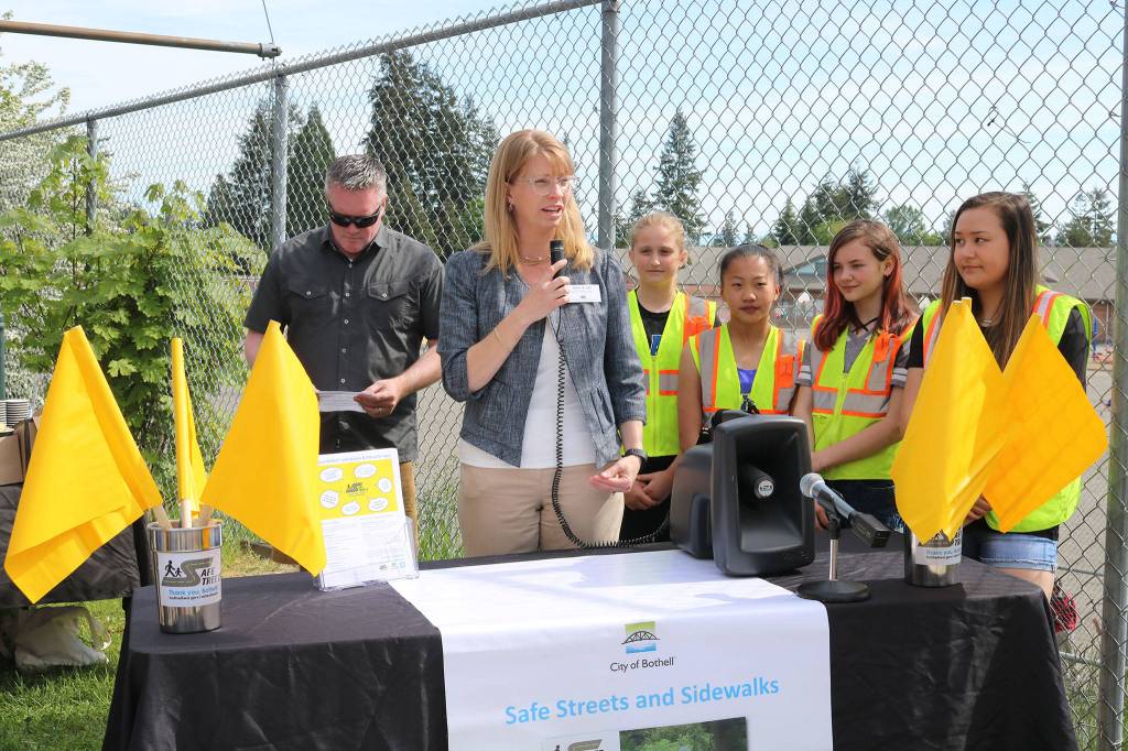 Bothell Mayor Andy Rheaume and Northshore School District Board President Amy Cast celebrate the installation of pedestrian flags at a variety of intersections near NSD schools alongside Frank Love Elementary School students. CATHERINE KRUMMEY / Bothell Reporter