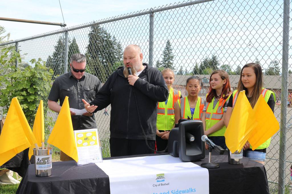 Bothell Mayor Andy Rheaume and Frank Love Elementary teacher Greg Wirtala celebrate the installation of pedestrian flags at a variety of intersections near Northshore School District schools alongside Frank Love students. CATHERINE KRUMMEY / Bothell Reporter