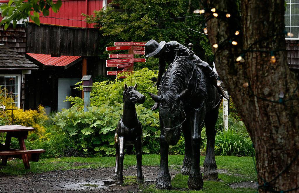 A whimsical sculpture of a western scene centers one of several cozy courtyards found between the shop buildings in Bothell&rsquo;s Country Village, Thursday. (Dan Bates / The Herald)