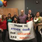 Doug Rough and his family thank Steven Charie (center, wearing glasses) for saving his life at 24-Hour Fitness in Bothell after the Kirkland City Council presented Charie with the Kirkland Community Hero award. Both men are Kirkland residents. Courtesy photo