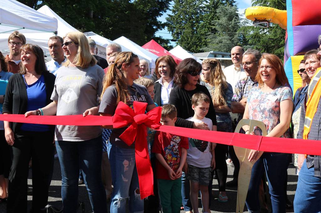 Kenmore Community Market manager Jenni Jensen (with the scissors) prepares to cut the ribbon to celebrate the market&rsquo;s opening. CATHERINE KRUMMEY / Bothell-Kenmore Reporter