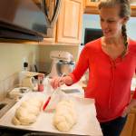 Joyce Sieben coats her cardamom bread with an egg wash before baking the braided loaves at her home in Bothell. Ian Terry, The Herald