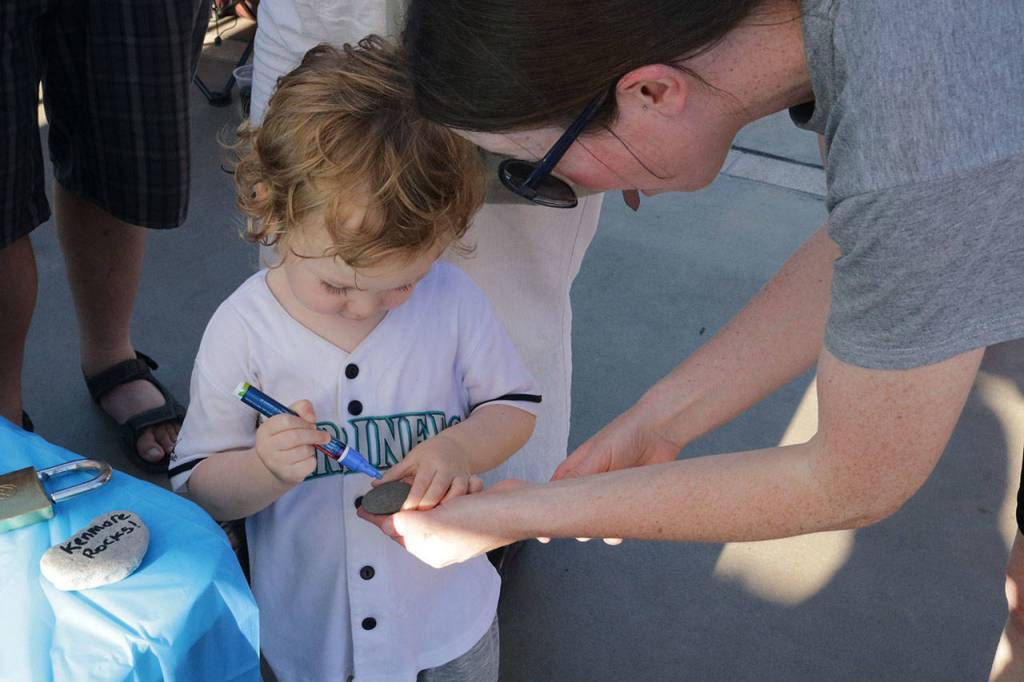 Megan Motley helps her son, Jack, 3, decorate a rock during the #WhyILoveKenmore Summer Party Saturday. Motley said she loves the fountain in the Town Square and the atmosphere of the city. Megan Campbell, Bothell/Kenmore Reporter