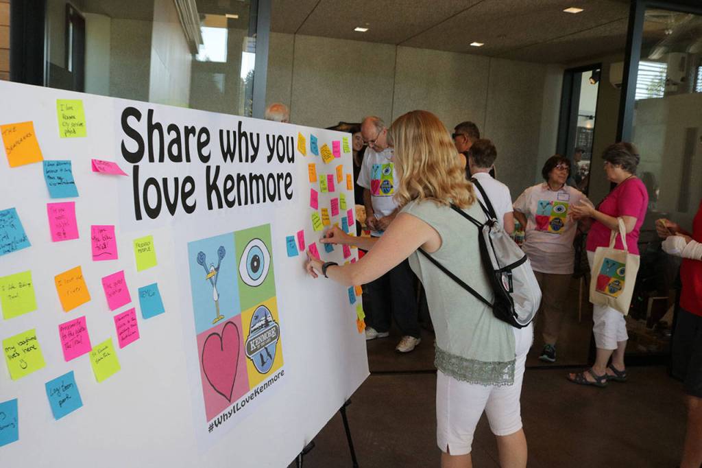 Amy Cast, of the Northshore School Board, puts a sticky note about why she loves Kenmore during the celebration Saturday. &ldquo;The people (in Kenmore) are beyond compare,&rdquo; she said. Megan Campbell, Bothell-Kenmore Reporter