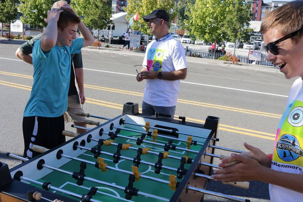 Mason Banks, 14, throws his hands up after losing to his older brother, Hunter, 16, during a game of table soccer during the #WhyILoveKenmore Summer Party Saturday. The boys&rsquo; father, Todd, is a partner at Kenmore Air. Their mother, Jayne, also works for Kenmore Air. When asked what they love about Kenmore, Jayne said &ldquo;the sea planes of course,&rdquo; adding that she also loves the community feeling. &ldquo;I just think there&rsquo;s really good energy in the community right now,&rdquo; Todd Hunter said. Megan Campbell, Bothell-Kenmore Reporter