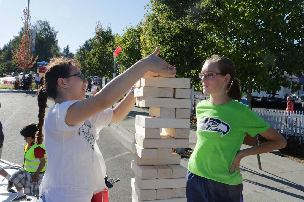 Amber Mehdipour, 14, stacks a Janga block during the #WhyILoveKenmore Summer Party Saturday while Grace Karlinsey, 14, looks on. Megan Campbell, Bothell/Kenmore Reporter