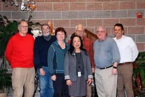 Fanny Yee (Center) stands among the Northshore Utility District Board of Commissioners along with Al Nelson (right), who is the incoming general manager. <em>Courtesy of the Northshore Utility District</em>