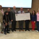 Bothell City Council members pose with Sen. Guy Palumbo (D-Maltby) and a $2 million check from the state, representing funds secured for preservation and conservation of land formerly occupied by the Wayne Golf Course. Photo via Twitter