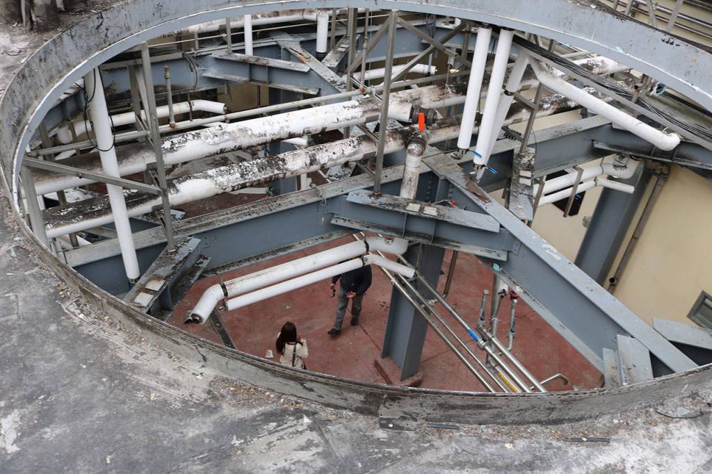 Jason Gorski and Keri Tawney can be seen through holes in ceiling in at the site of a planned three-story tower for DeLille Cellars at the old Redhook brewery in Woodinville. Aaron Kunkler/Staff photo