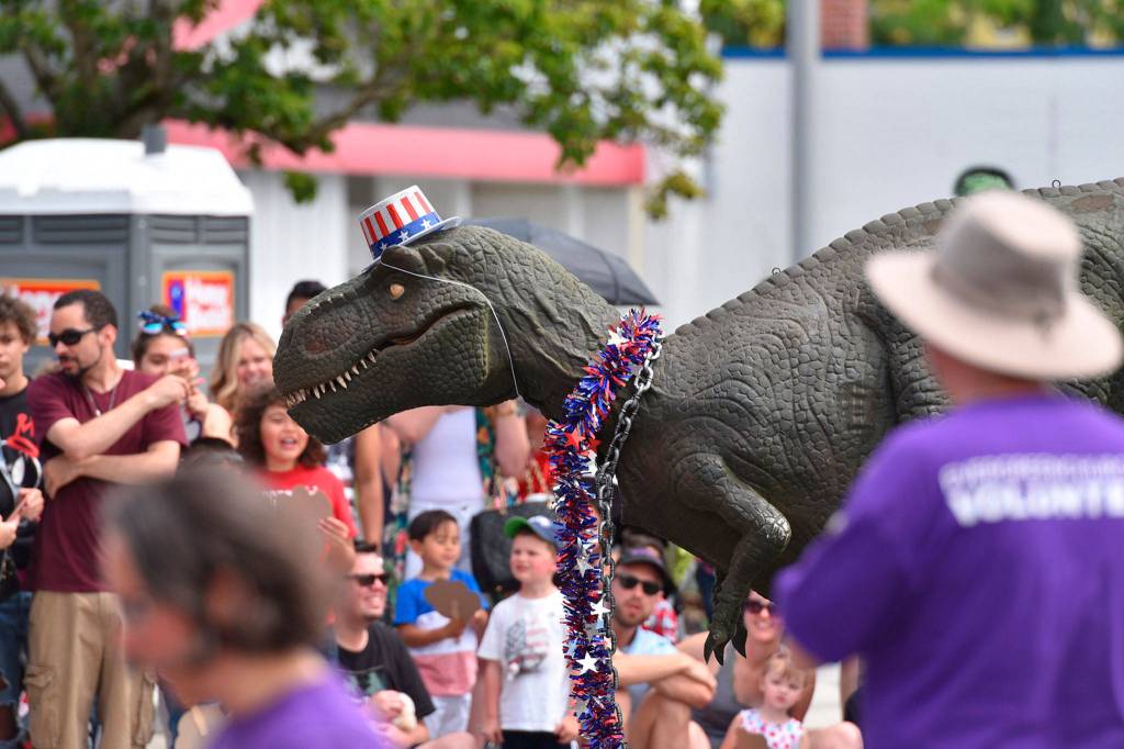 A friendly dinosaur from a birthday party planning company marches in the parade. Photo courtesy of Greg Nelson