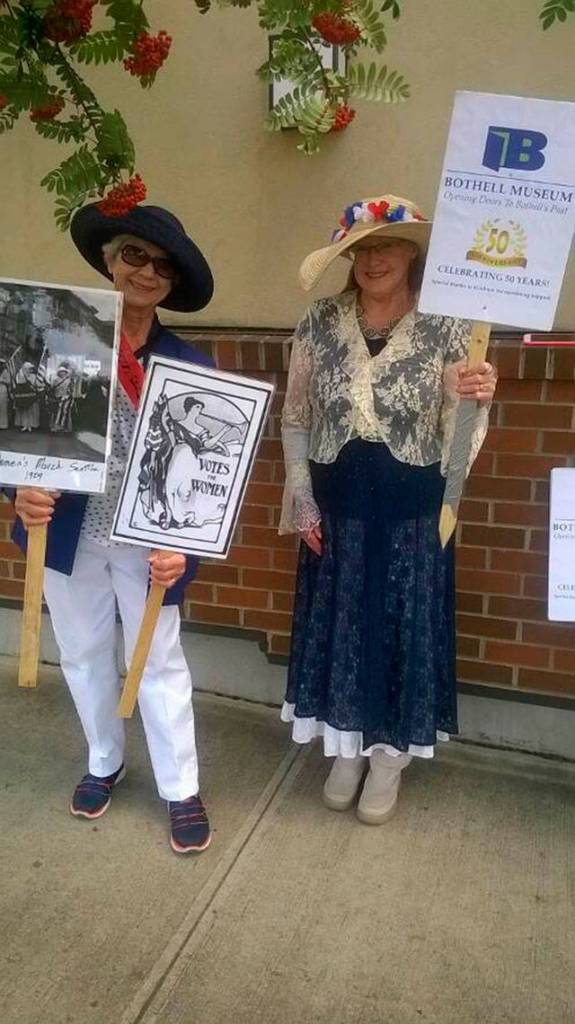 Margaret Carroll (left) and Nancy Velando hold signs that advocate for womens rights, based on the suffragettes from 1920. Courtesy of the Bothell Historical Museum