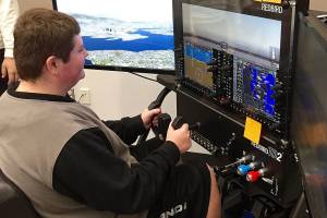 North Creek High School junior Austin Mitchell learns to fly using a $14,000 Redbird flight simulator in Northshore School Districts new Introduction to Aviation class. Photo courtesy of Northshore School District.