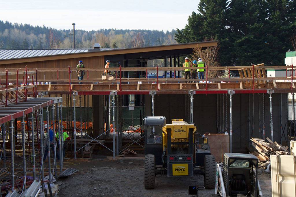 Work crews construct the first floor of Kenmores newest downtown development, the Flyway. The building is adjacent to the Hangar, Kenmores community center, and will be a mixed retail and residential space.